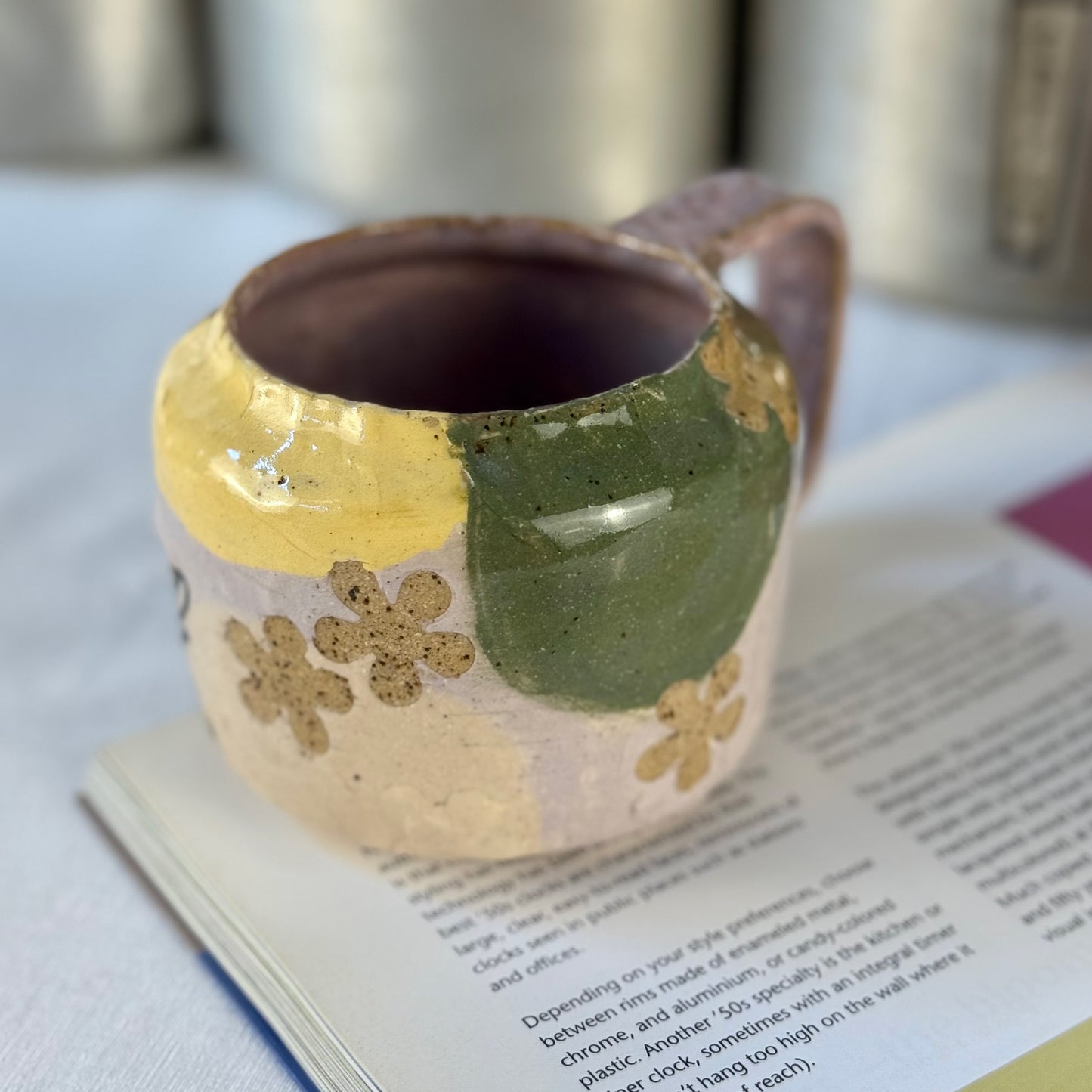 Ceramic mug with floral patterns on a book