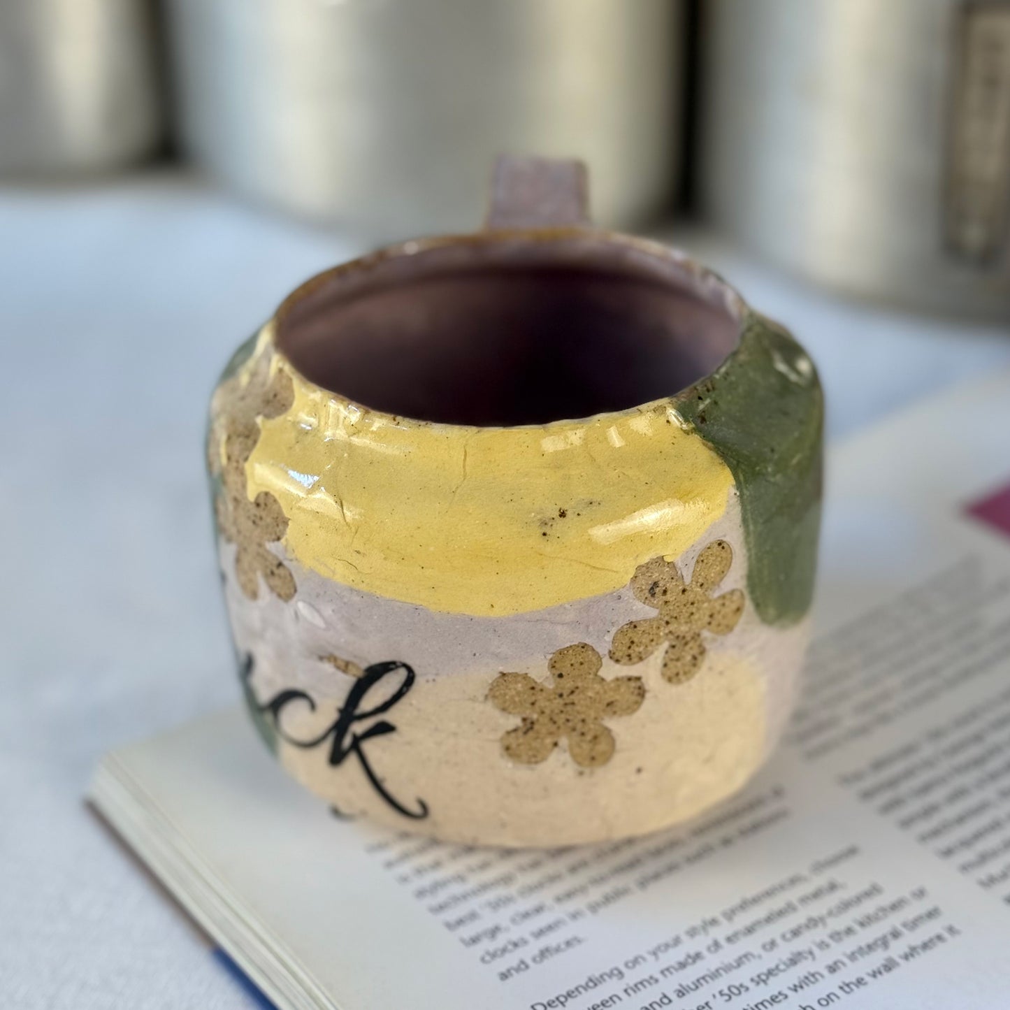 Decorative ceramic cup with floral patterns on a book