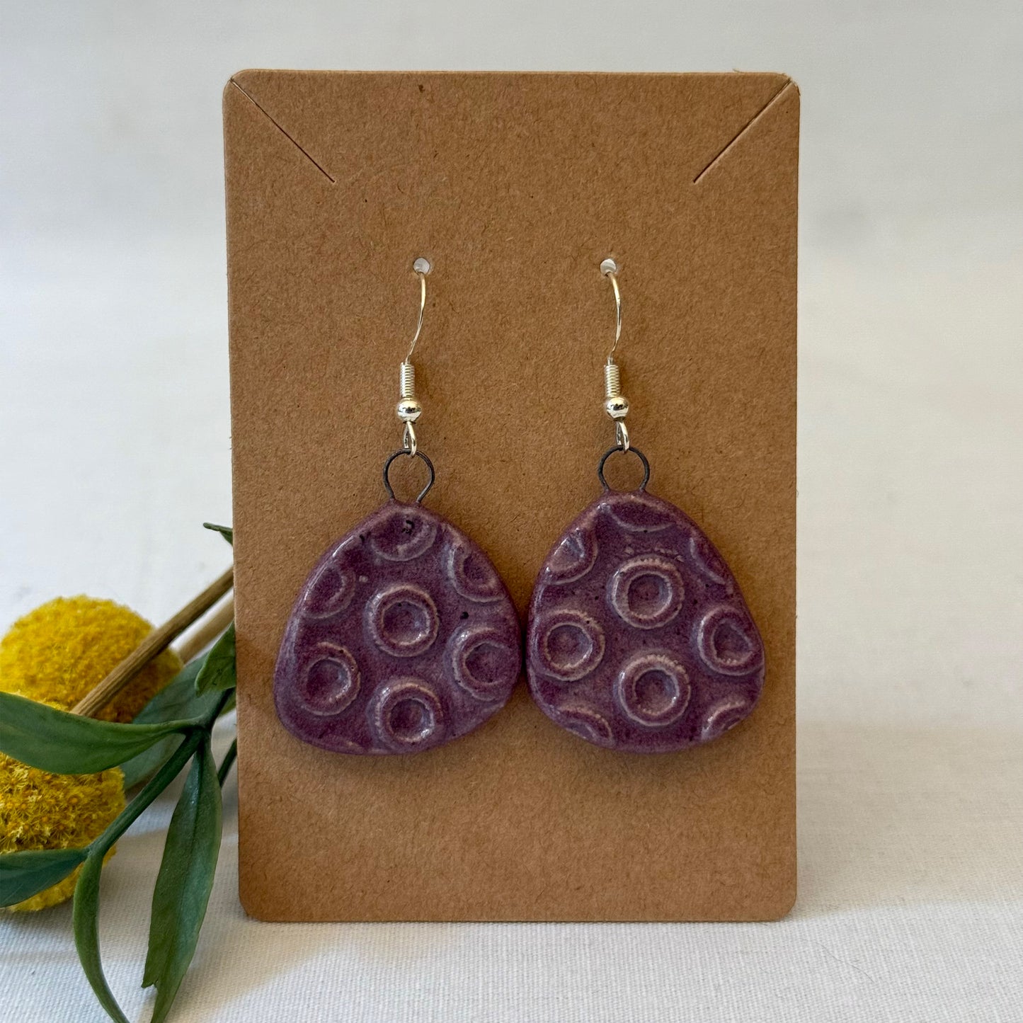 Plum earrings with circles on brown card