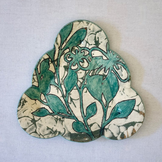 Decorative plate with aqua botanical pattern on a light background