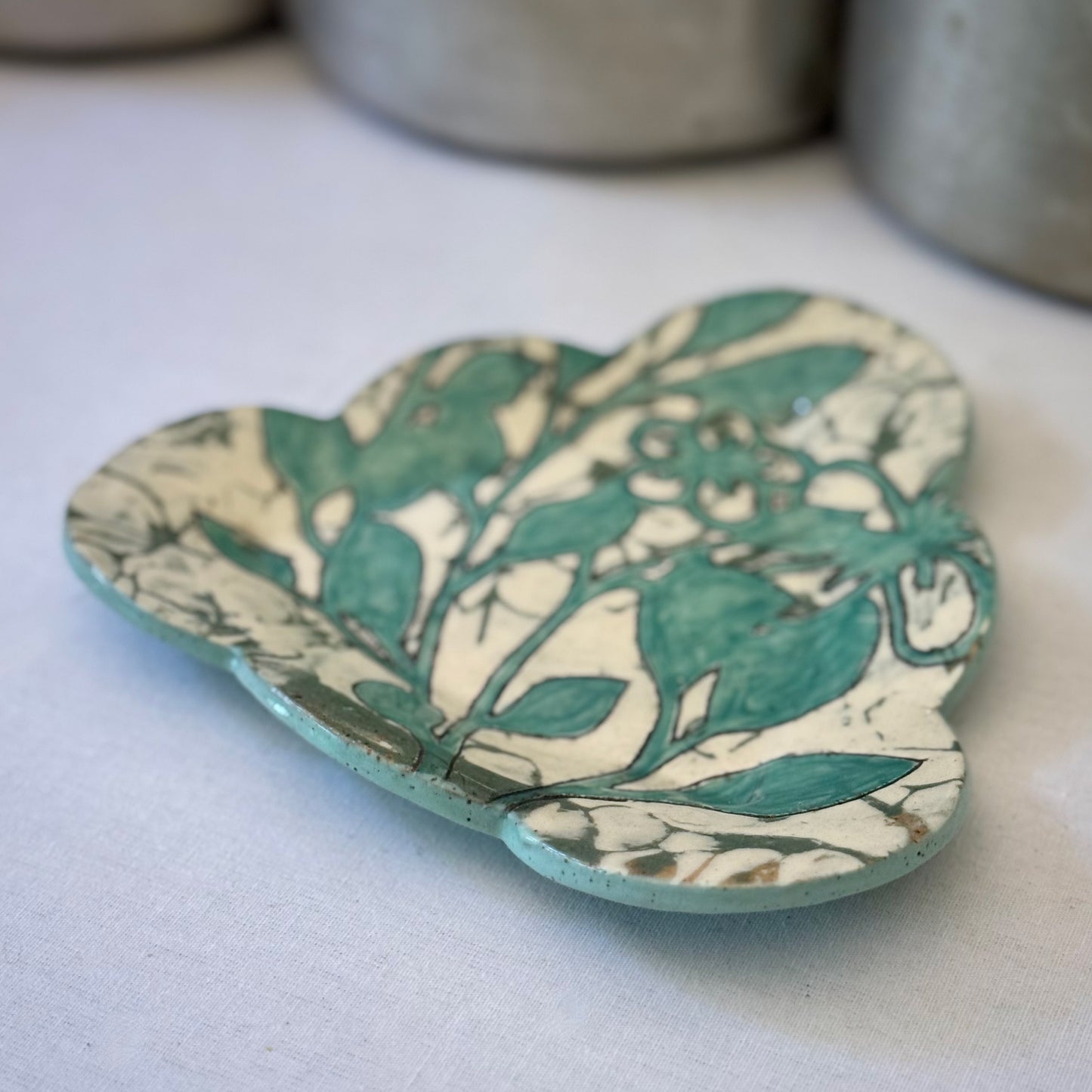 Decorative plate with aqua botanical pattern on a light background