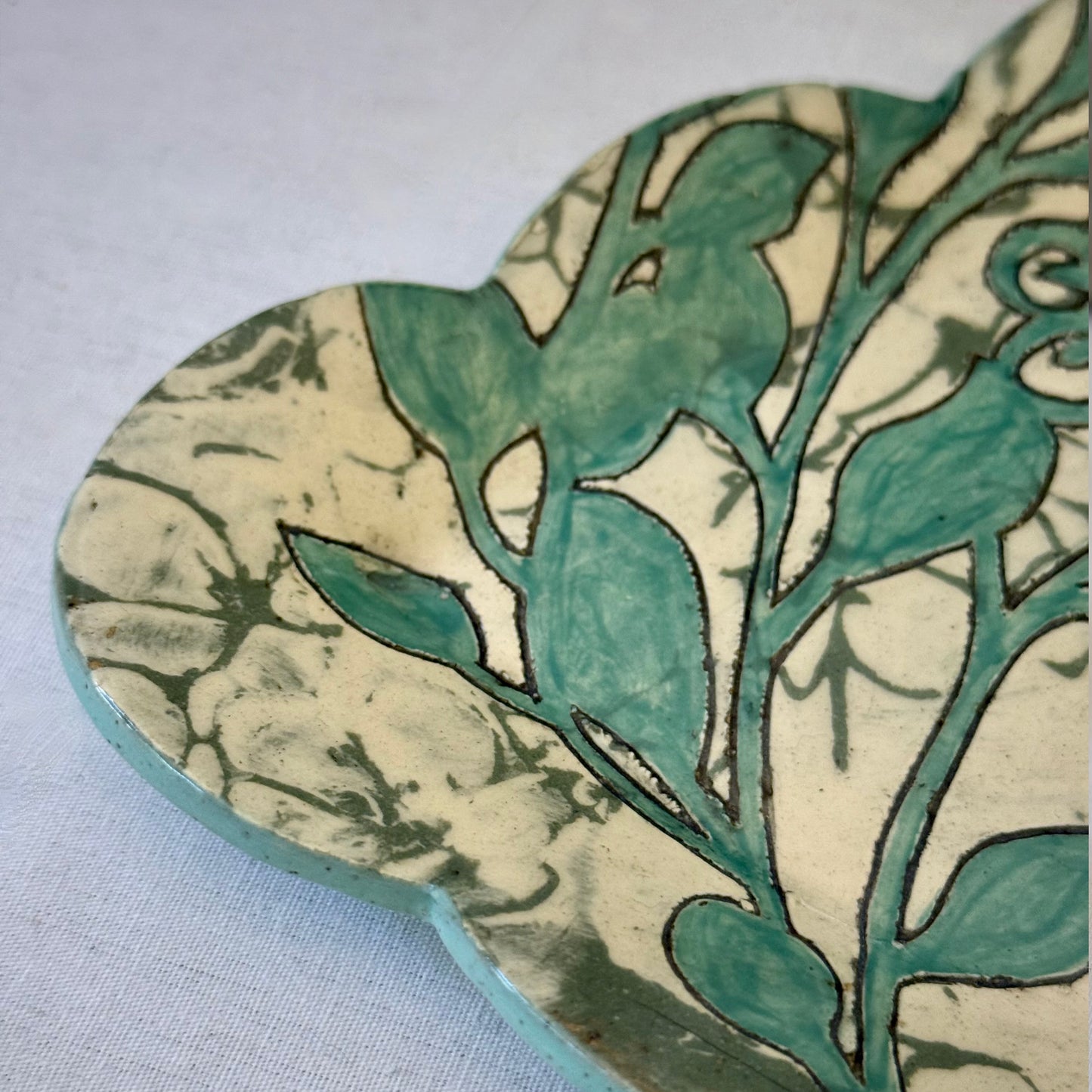 Decorative plate with aqua botanical pattern on a light background