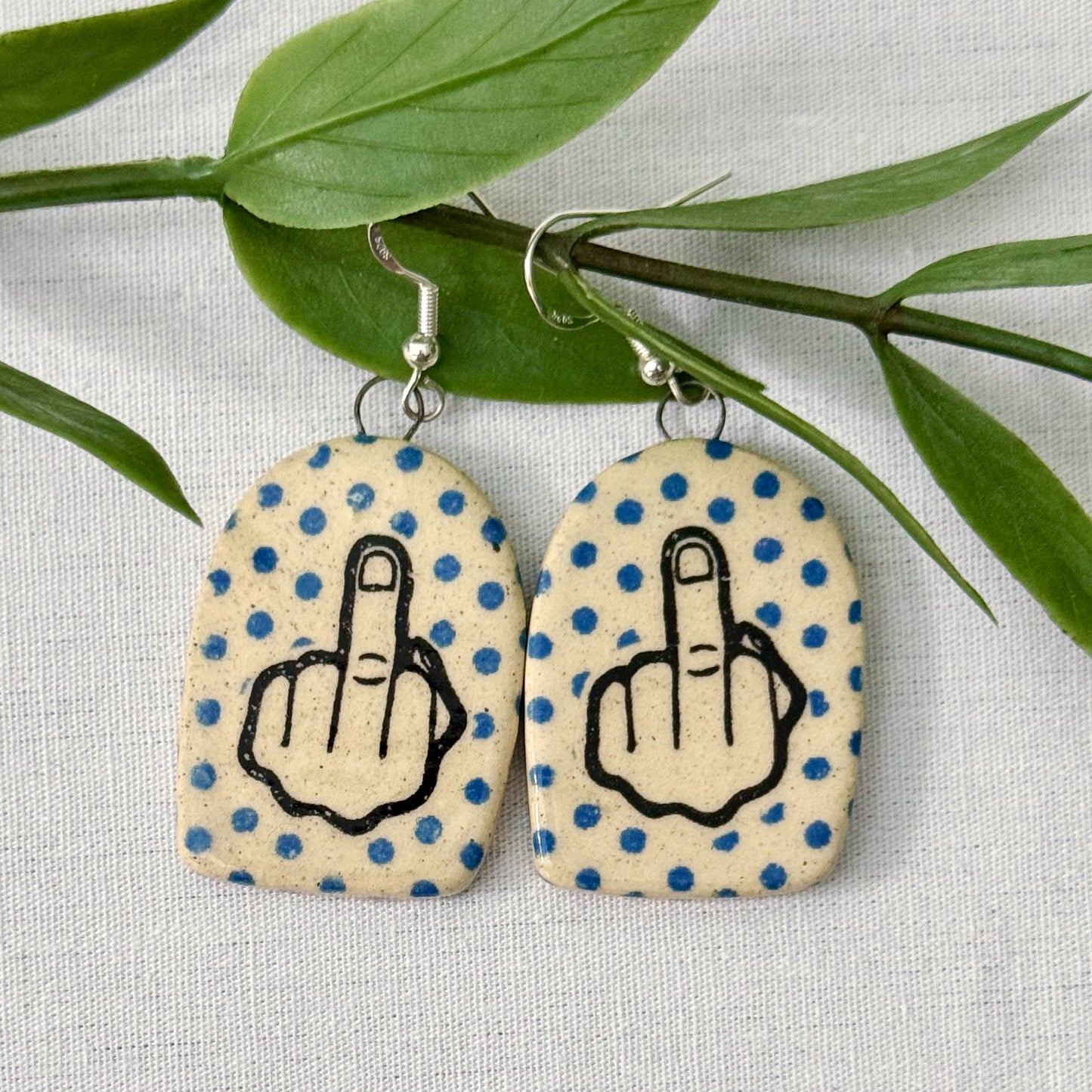 Earrings with polka dot pattern and middle finger design