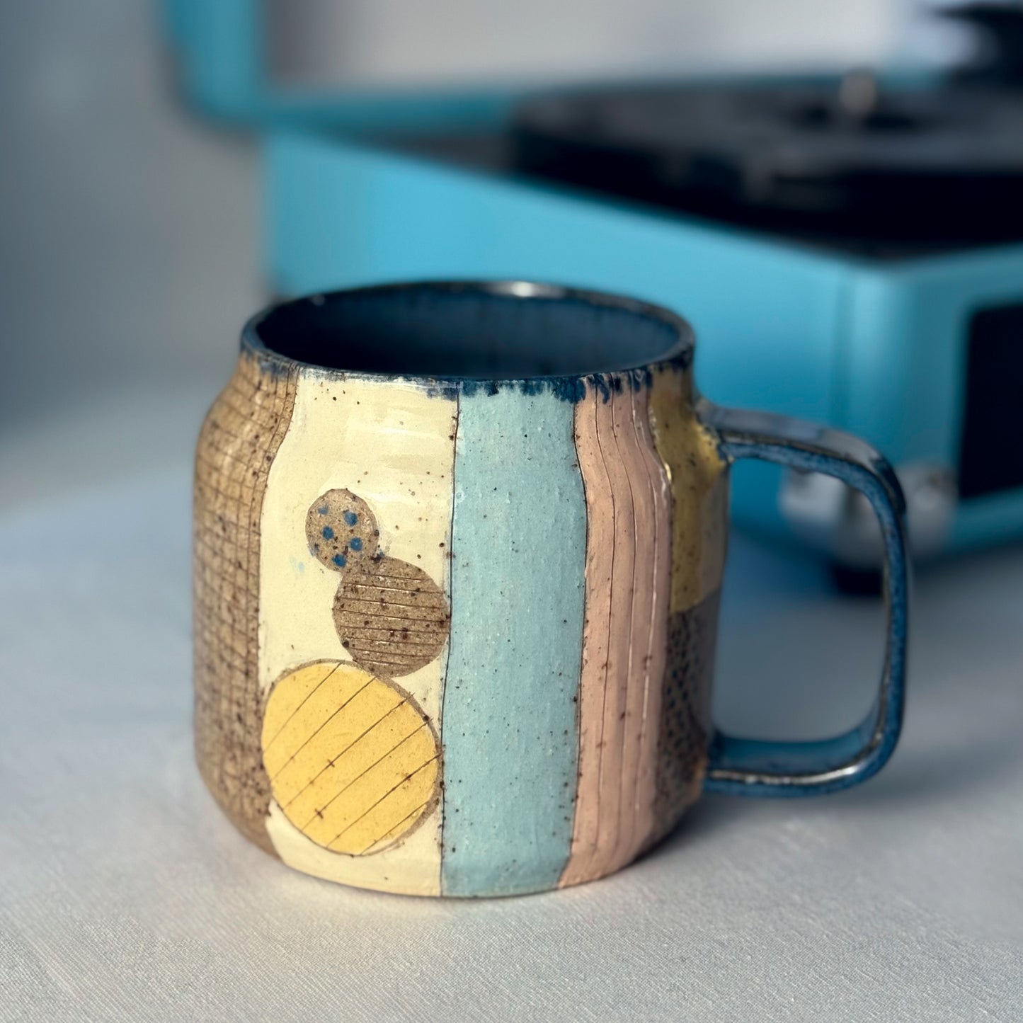 Ceramic mug with textured design on a neutral background