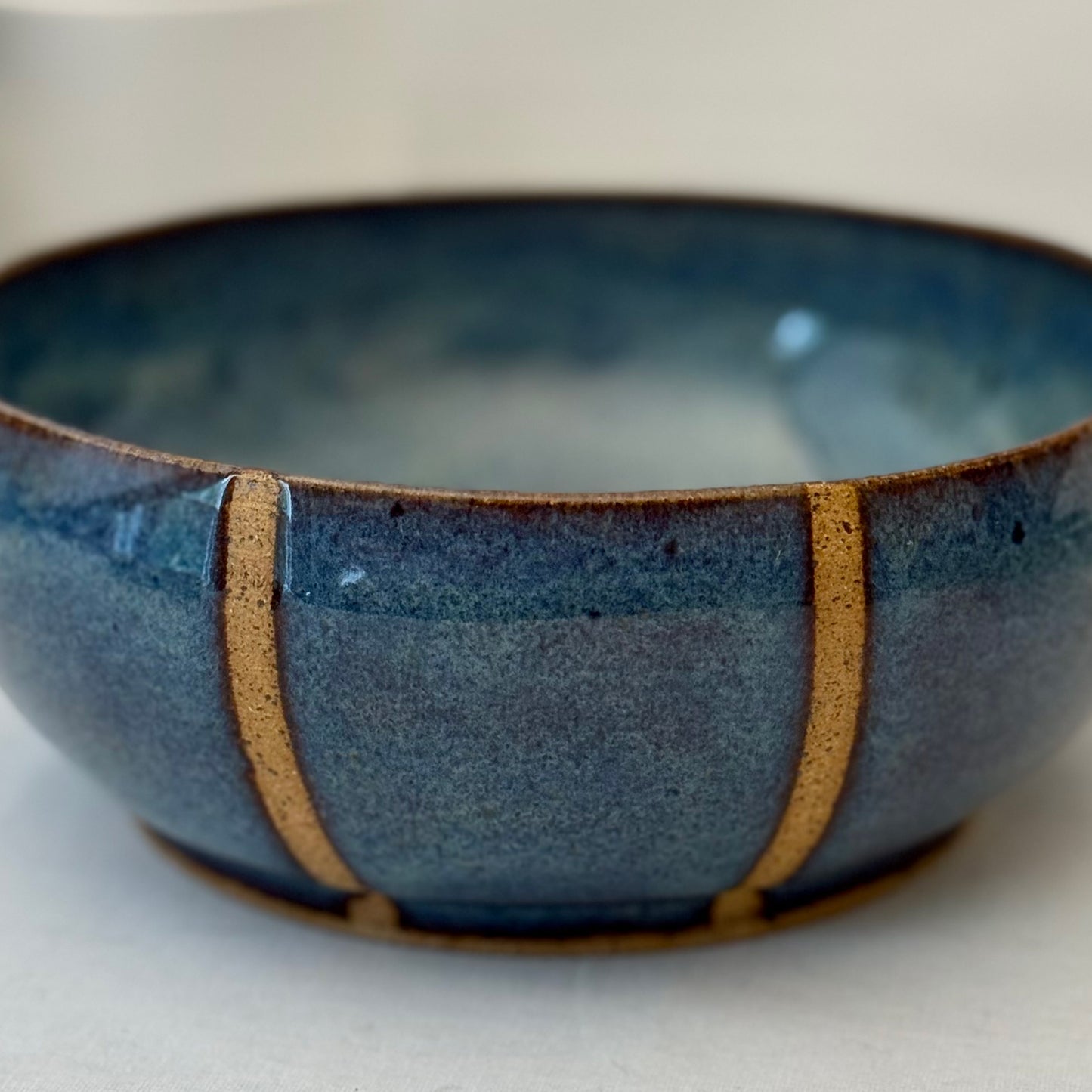 Blue ceramic bowl with brown accents on a white background