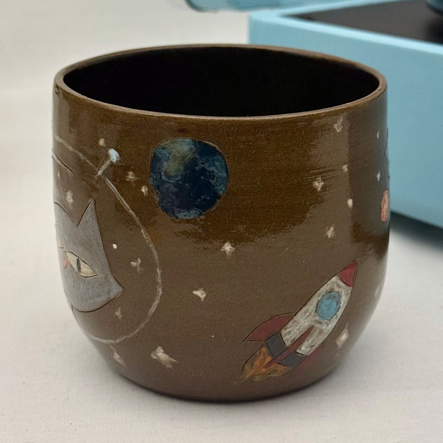 Ceramic mug with space-themed design on a white surface