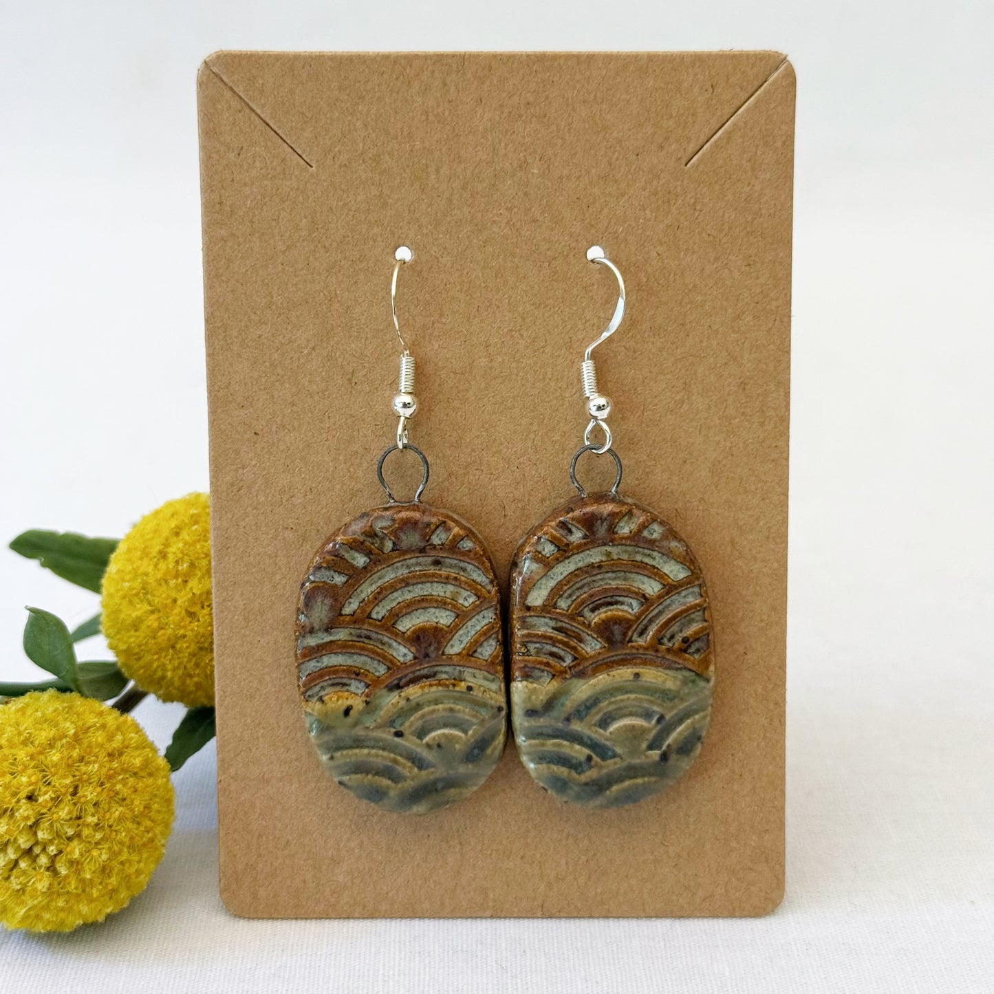 Oval earth tone earrings on brown card