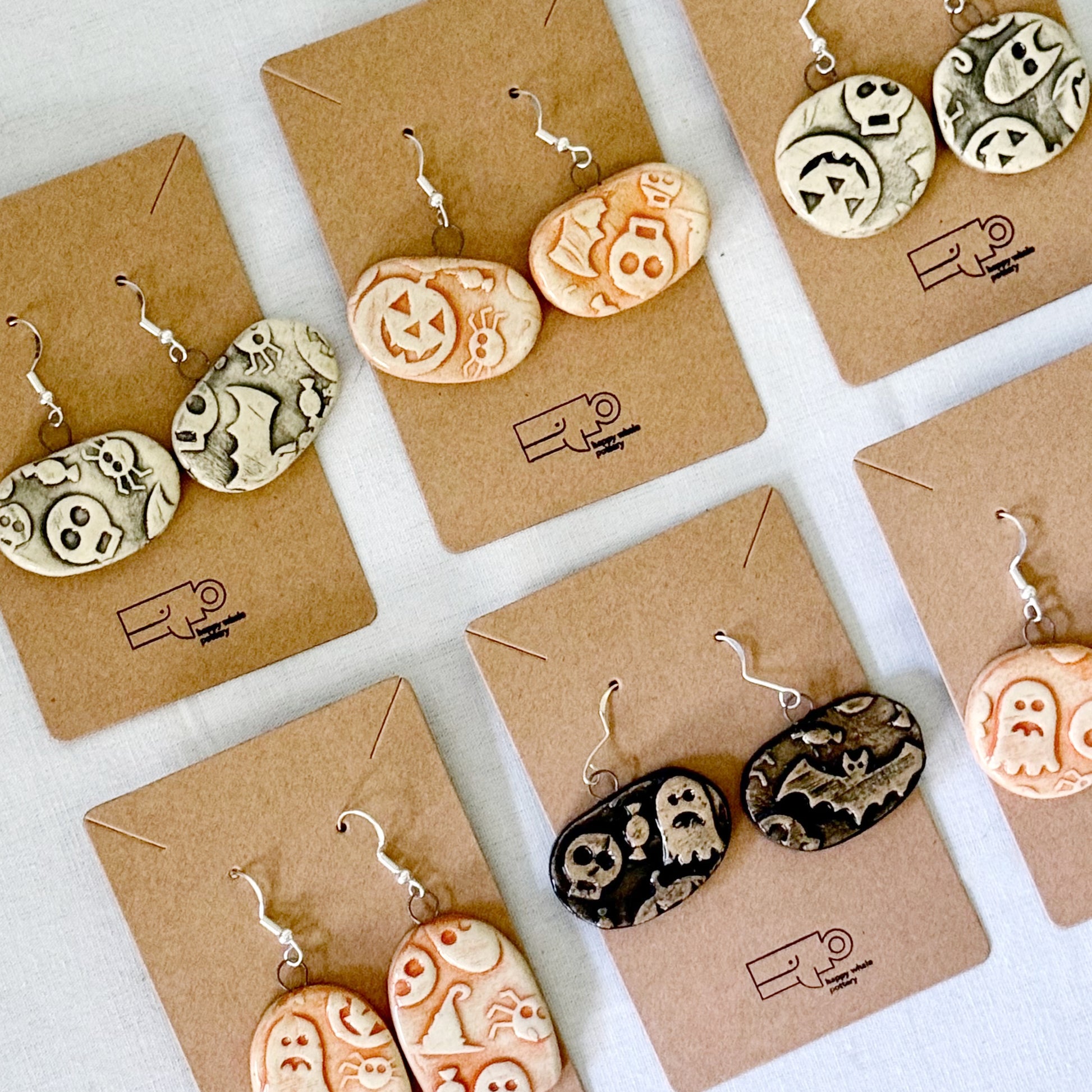 halloween themed ceramic earrings on brown cards with a white background