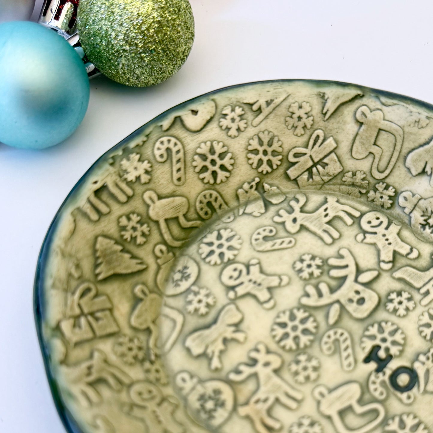 close-up of green and ivory ceramic oval plate with "ho ho ho"