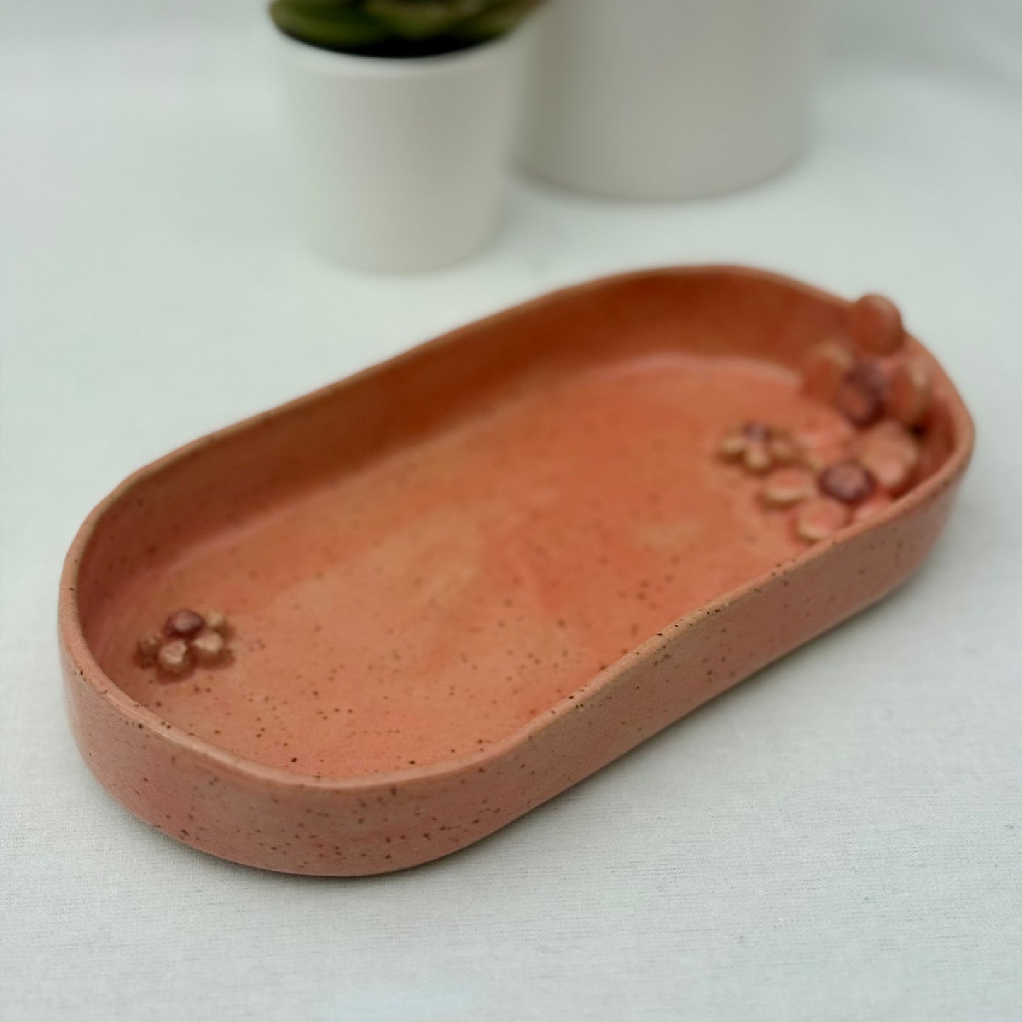 Pink ceramic dish with floral design on a white surface