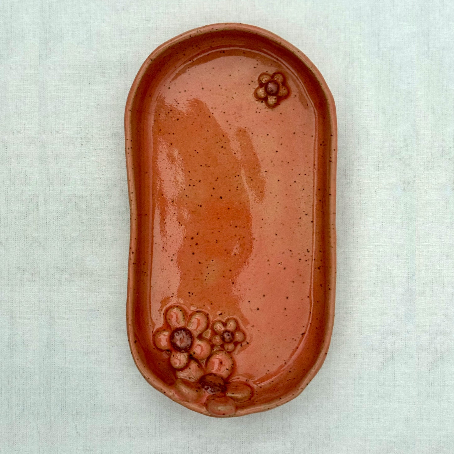 Pink ceramic dish with floral design on a white surface