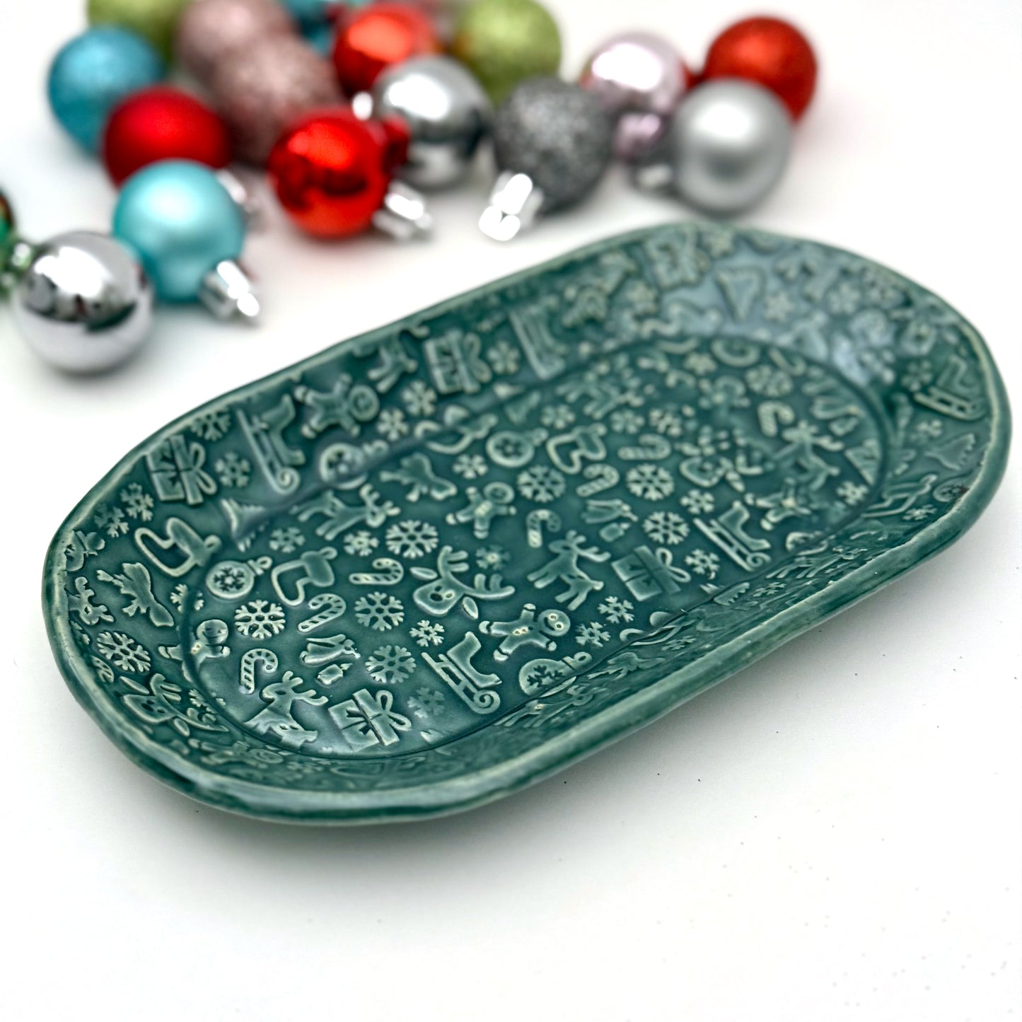 Decorative green plate with holiday patterns on a white background with colorful ornaments.