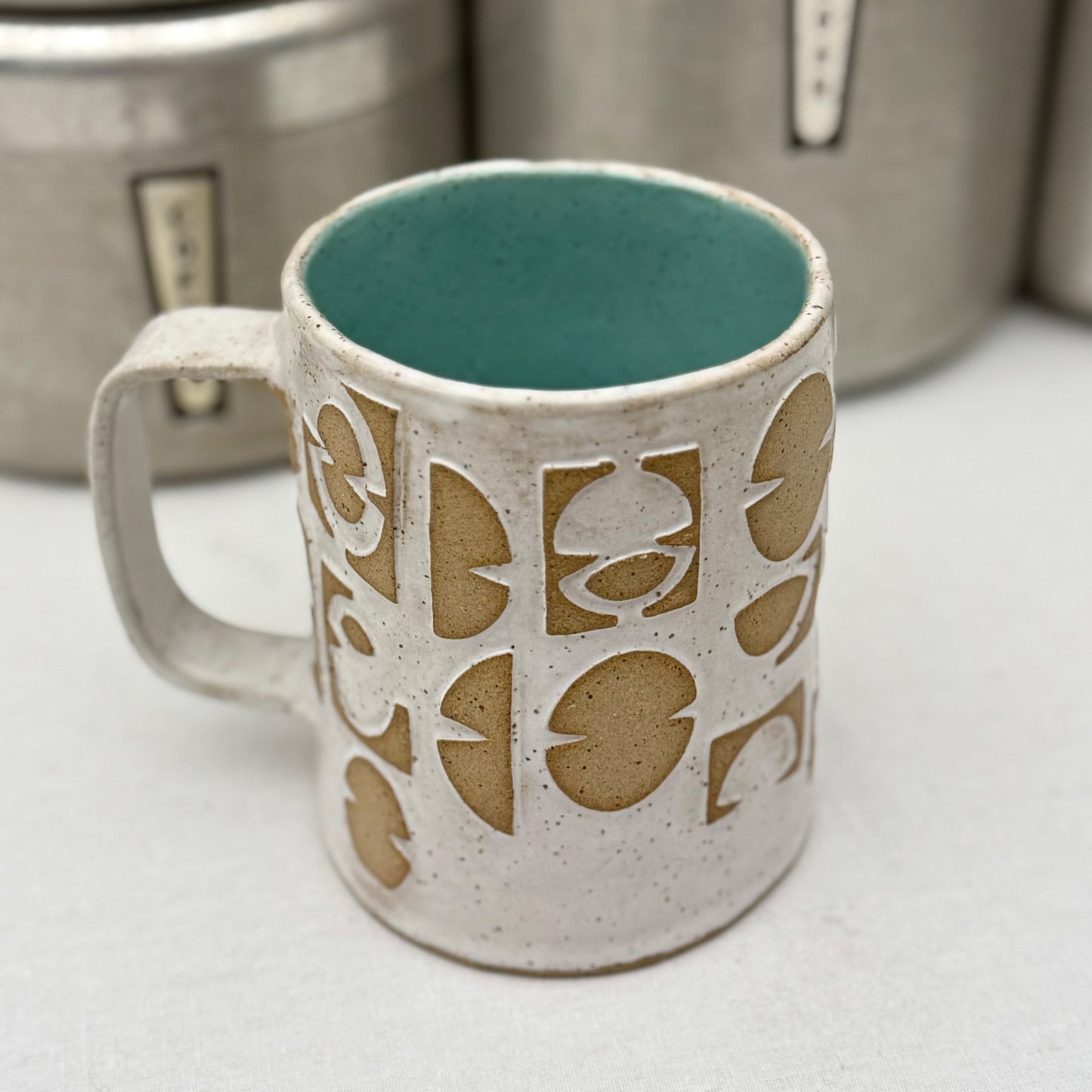 Ceramic mug with decorative patterns on a white surface