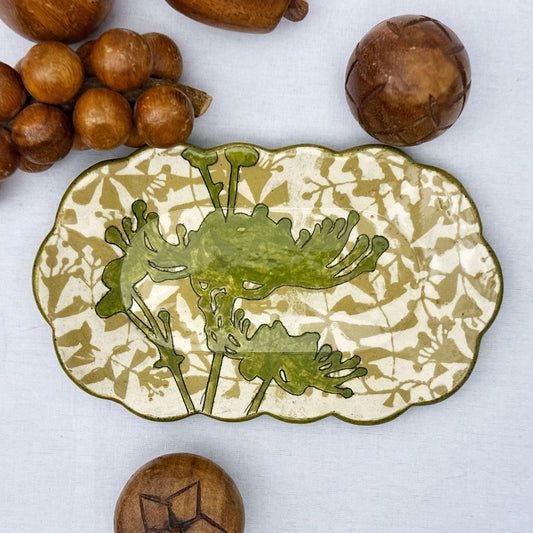 Decorative ceramic plate with olive green floral design on a beige and brown patterned background