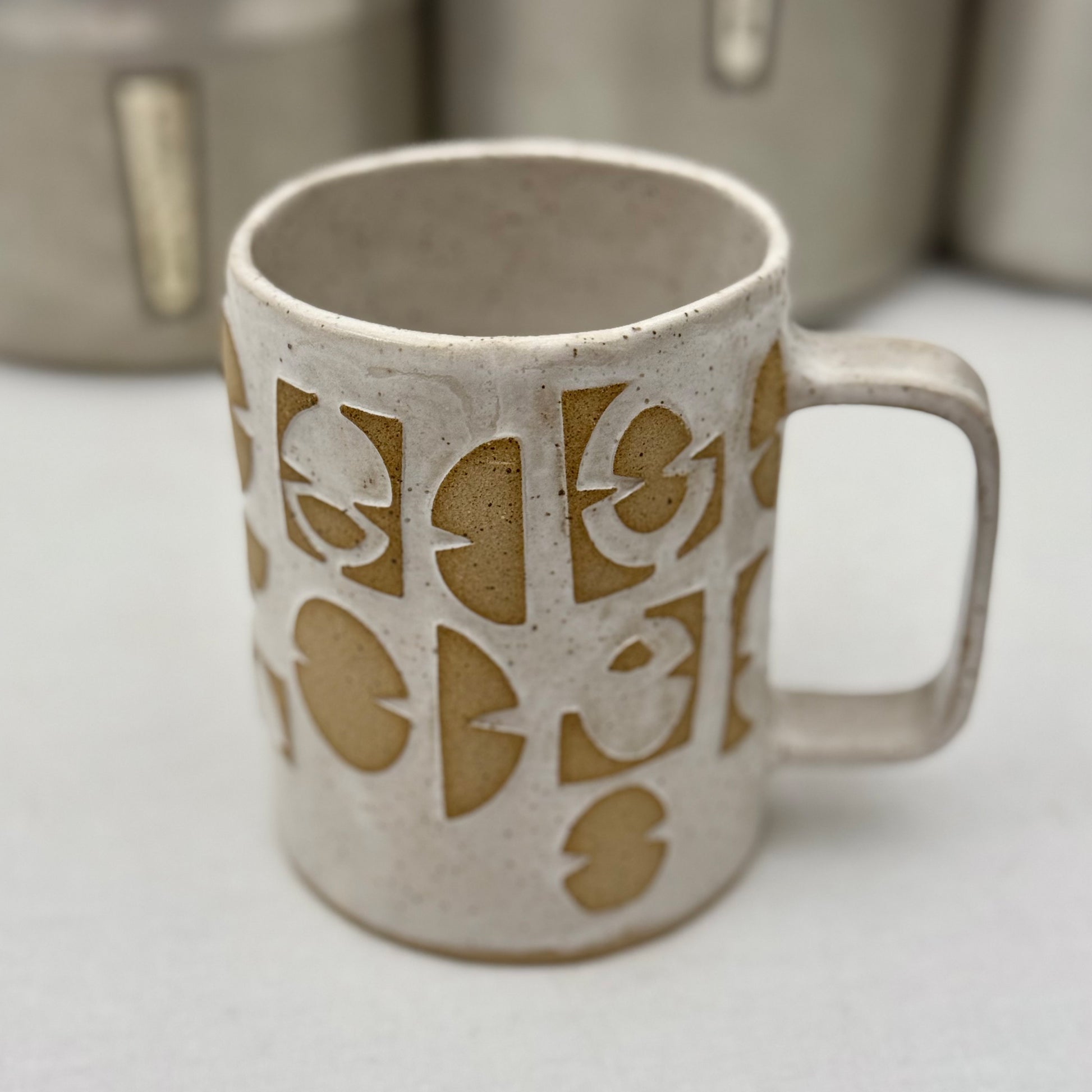 Ceramic mug with decorative patterns on a white surface