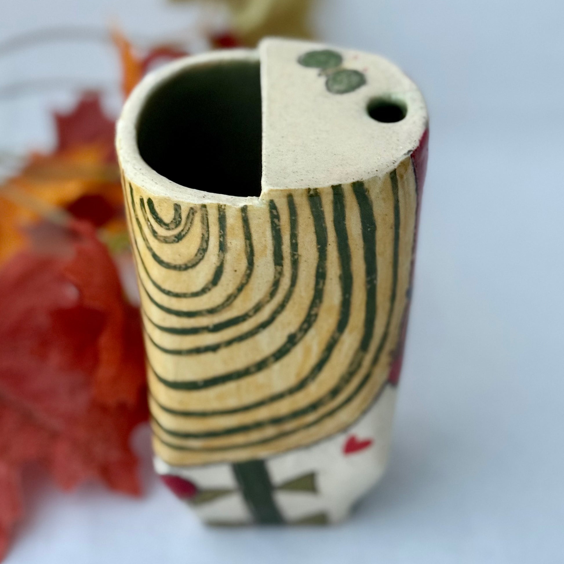 ceramic to go tumbler with flower and cat design on light background with leaves