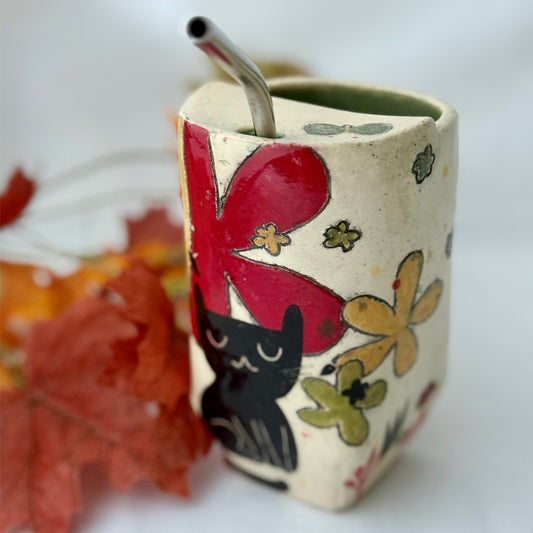 ceramic to go tumbler with flower and cat design on light background with leaves