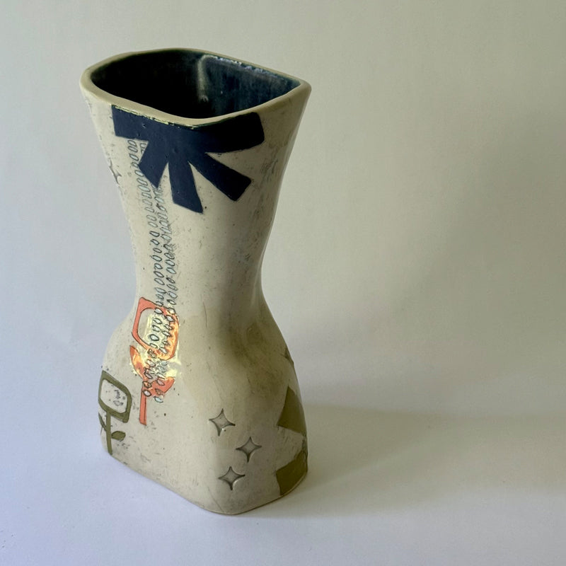 Handcrafted ceramic vase featuring mid-century inspired geometric patterns, floral motifs, and an hourglass shape.