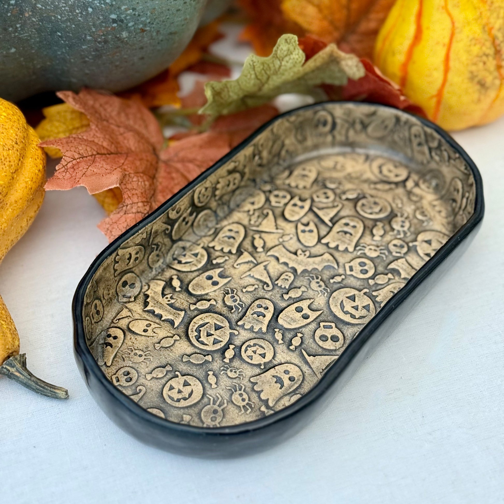 Decorative ceramic tray with Halloween-themed pattern surrounded by pumpkins and leaves
