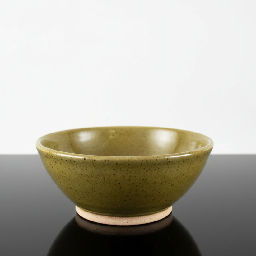 A handmade ceramic bowl with a speckled olive glaze