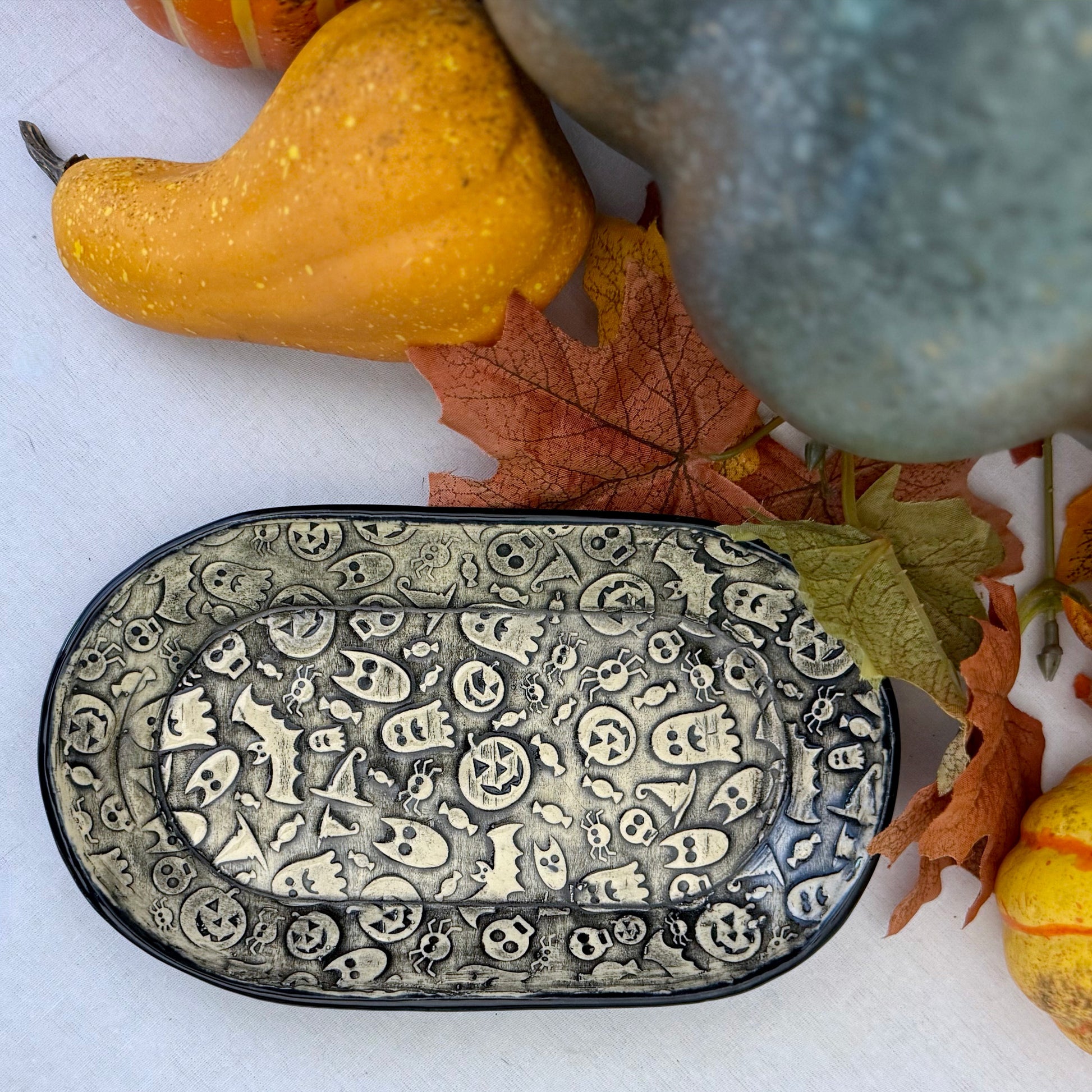 Halloween themed oval plate on light background with leaves and pumpkins
