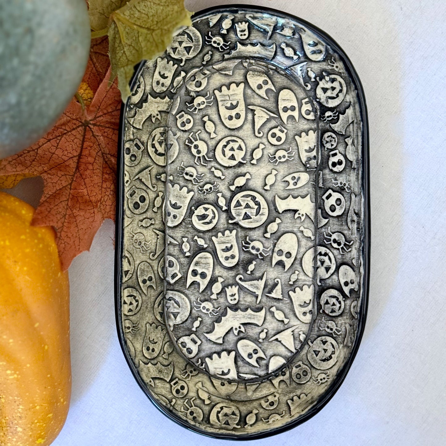 Halloween themed oval plate on light background with leaves and pumpkins