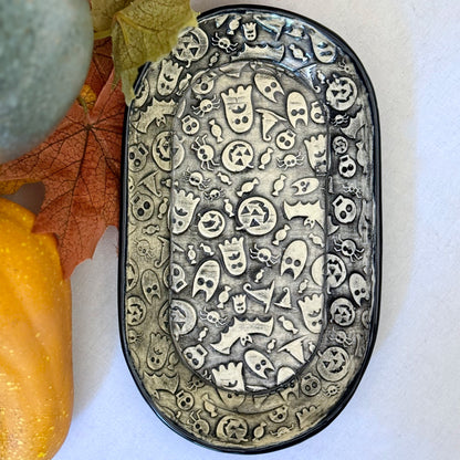 Halloween themed oval plate on light background with leaves and pumpkins