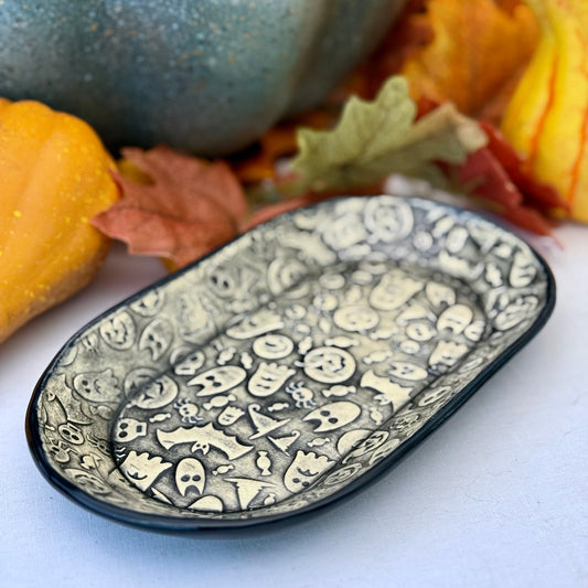 Halloween themed oval plate on light background with leaves and pumpkins