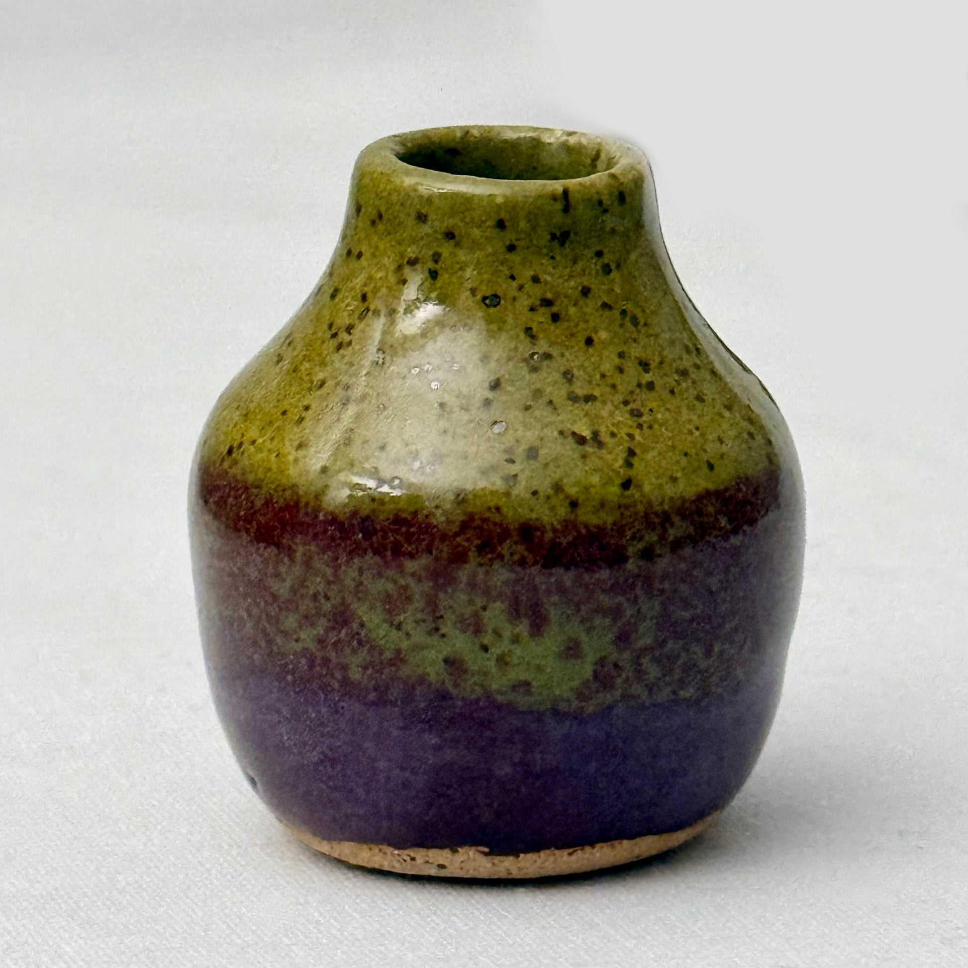 Small olive and purple ceramic vase on a white background