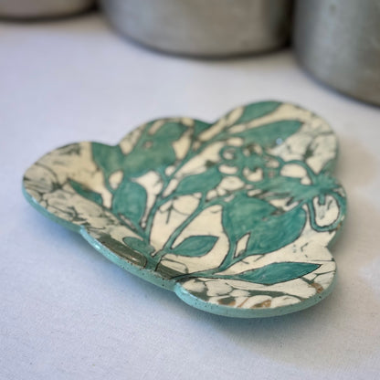 Decorative plate with aqua botanical pattern on a light background