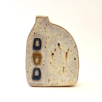 Mid-century modern ceramic vase with three raised turquoise and olive green geometric shapes on a speckled cream stoneware body.