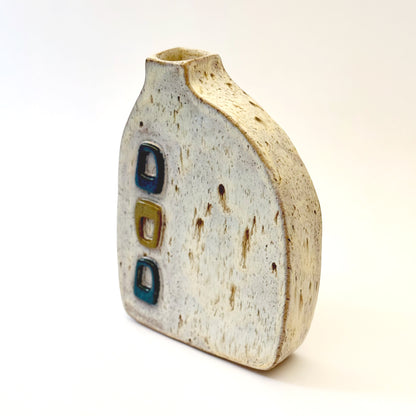 Mid-century modern ceramic vase with three raised turquoise and olive green geometric shapes on a speckled cream stoneware body.