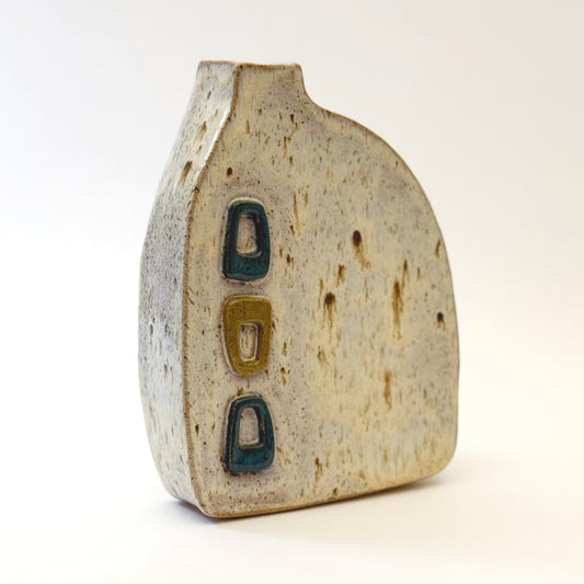 Mid-century modern ceramic vase with three raised turquoise and olive green geometric shapes on a speckled cream stoneware body.