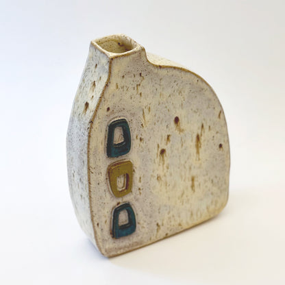 Mid-century modern ceramic vase with three raised turquoise and olive green geometric shapes on a speckled cream stoneware body.