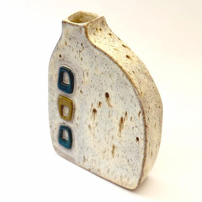 Mid-century modern ceramic vase with three raised turquoise and olive green geometric shapes on a speckled cream stoneware body.