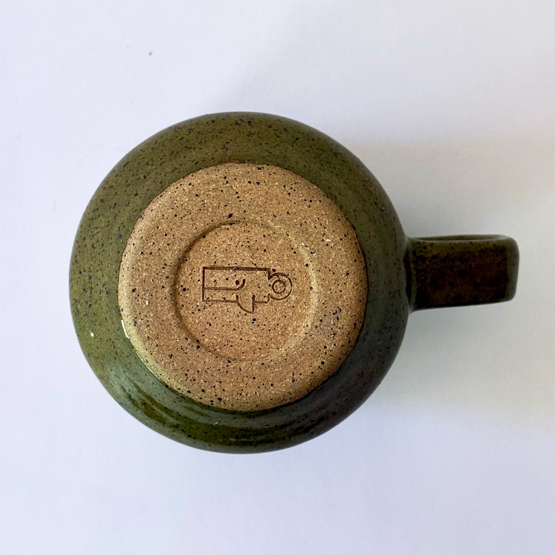 Glossy olive-green speckled mug featuring a contrasting mid-century geometric breeze block pattern.