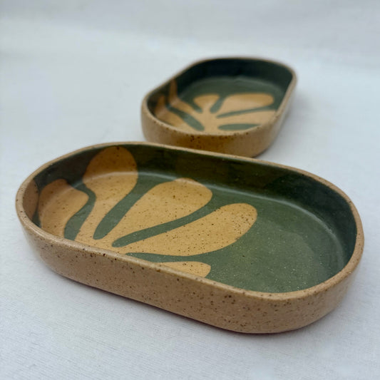 Two ceramic trays with leaf patterns on a white background