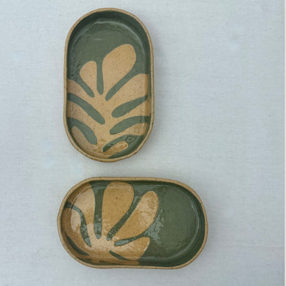 Two ceramic trays with leaf patterns on a light gray background