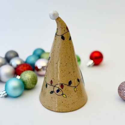 ceramic gnome with holiday lights with ornament on a white background