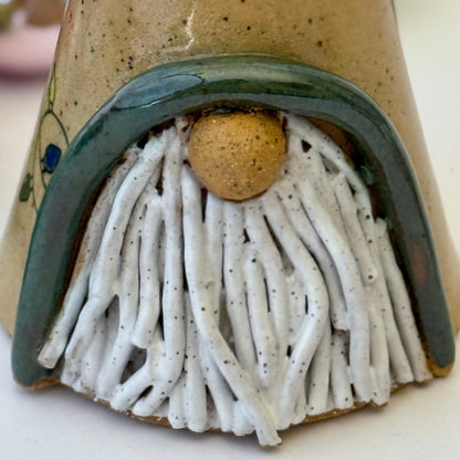 close-up of ceramic gnome with holiday lights 