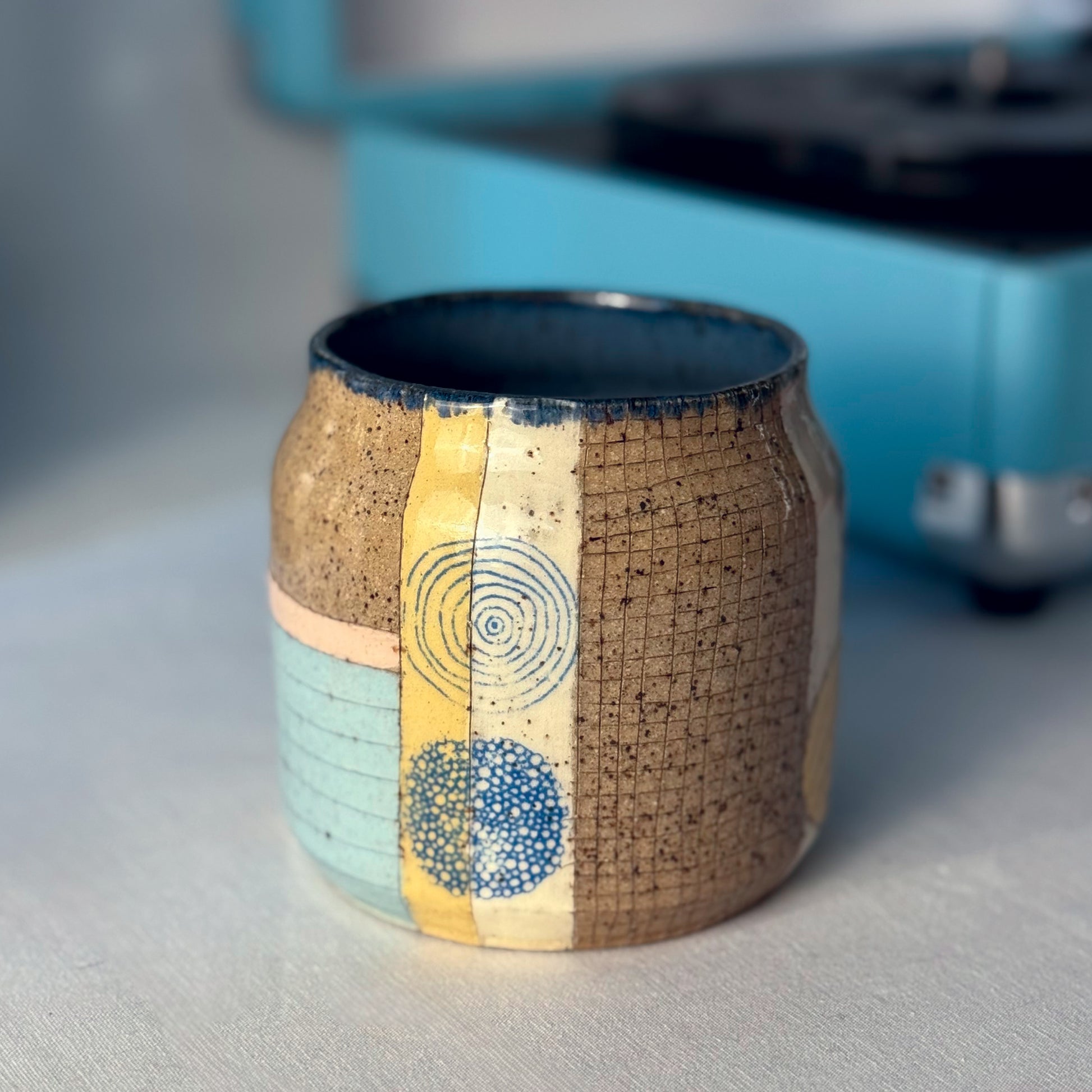 Ceramic mug with textured design on a gray surface