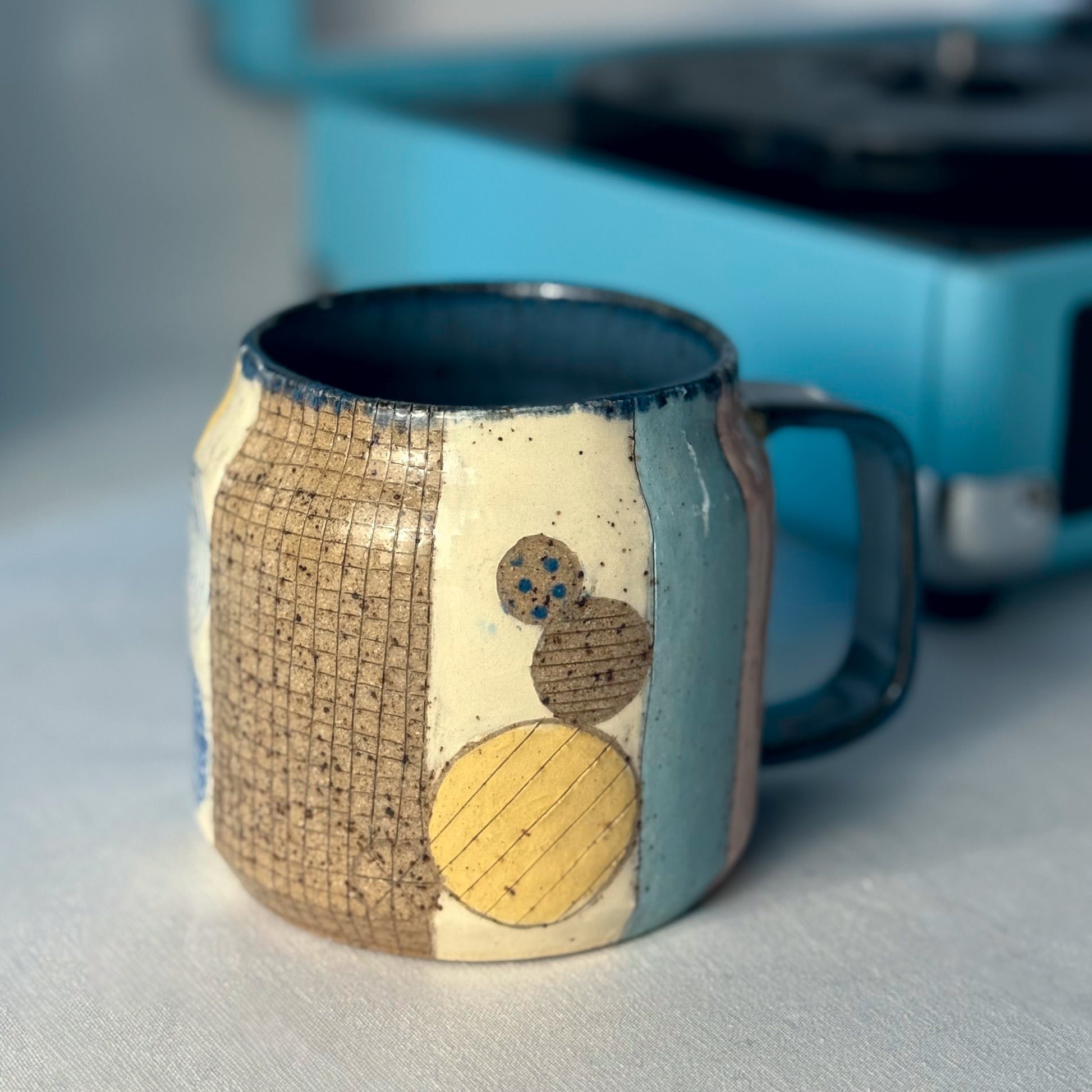 Ceramic mug with artistic design on a light surface