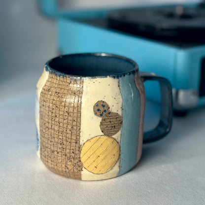 Ceramic mug with artistic design on a light surface