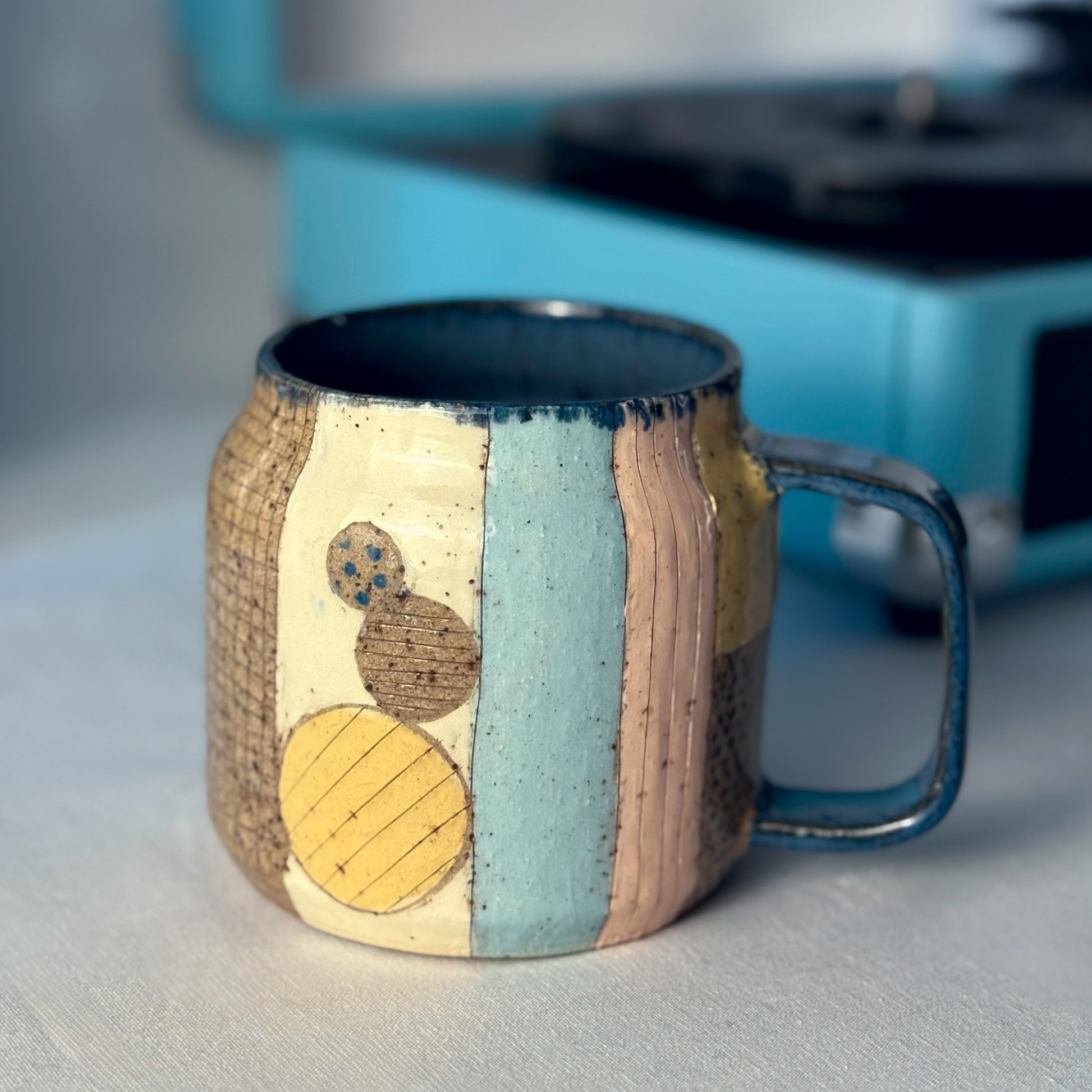 Ceramic mug with textured design on a neutral background