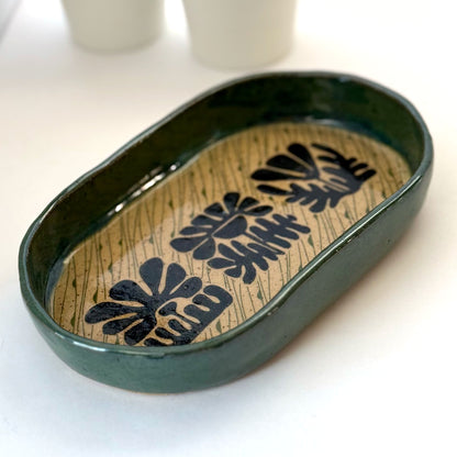 Decorative ceramic tray with floral patterns on a white surface