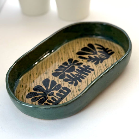 Decorative ceramic tray with floral patterns on a white surface