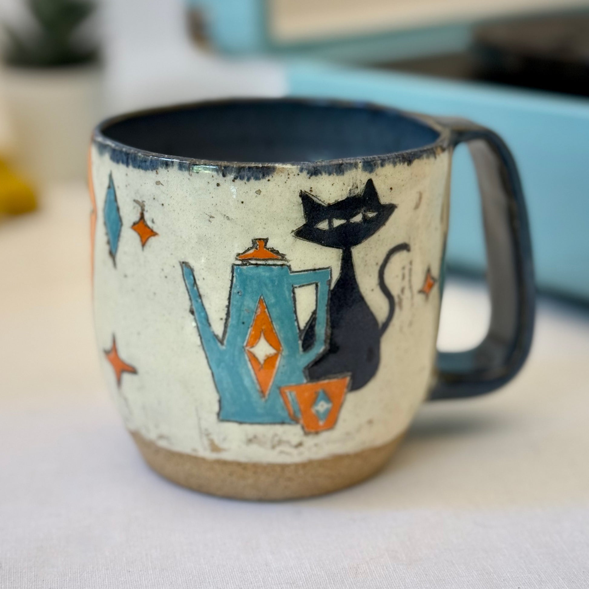 Stoneware mug featuring black cat and retro coffee pot in orange and blue