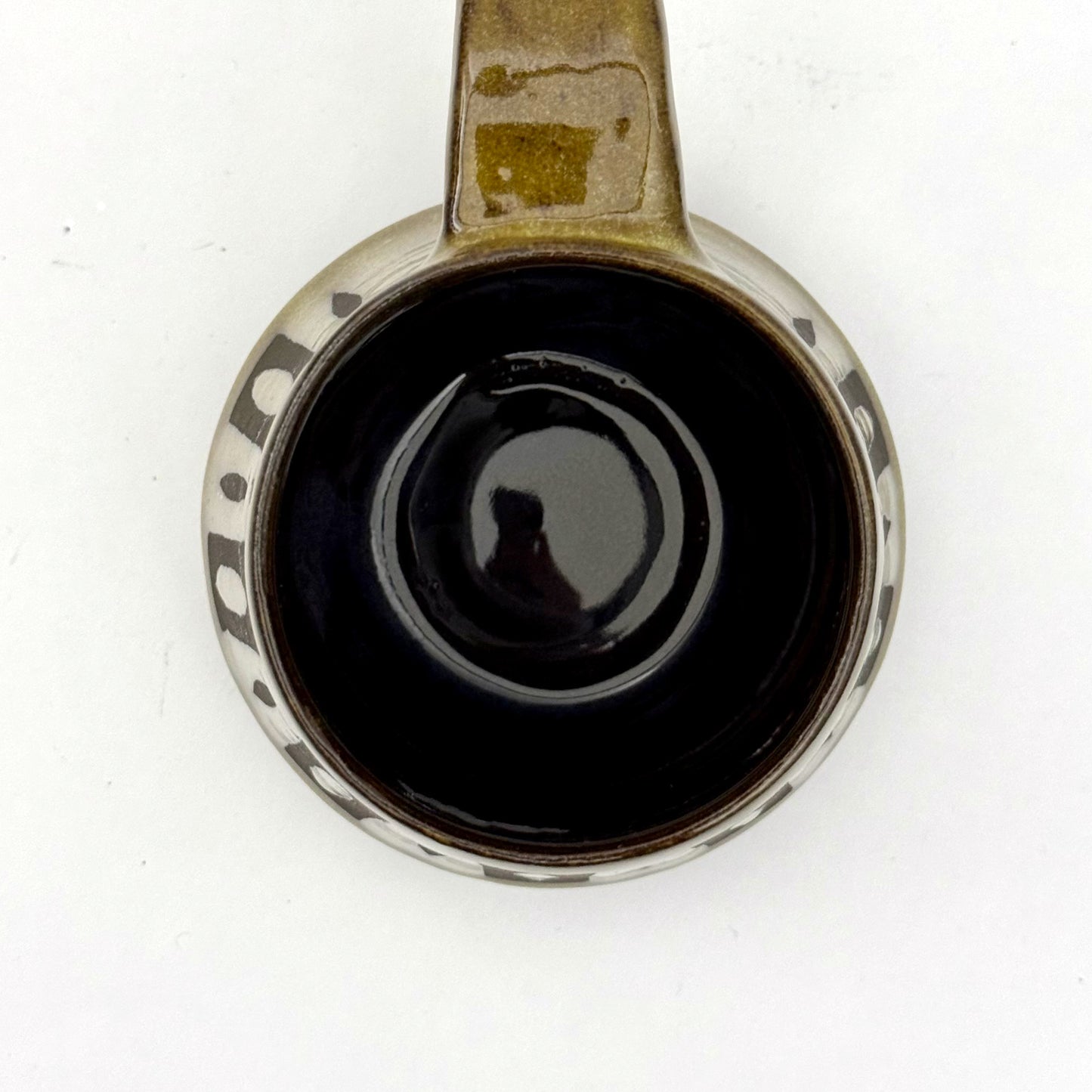 Top view of a handmade ceramic mug with a bold mid-century–inspired vertical tape-resist pattern.