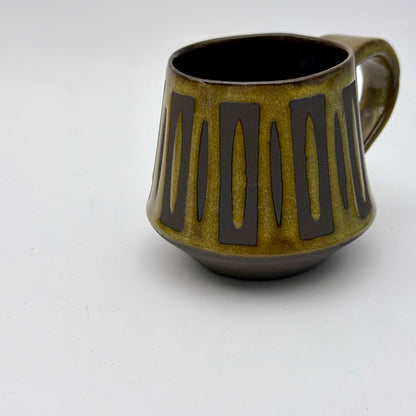 Handmade ceramic mug finished in Curry glaze with a bold mid-century–inspired vertical tape-resist pattern.
