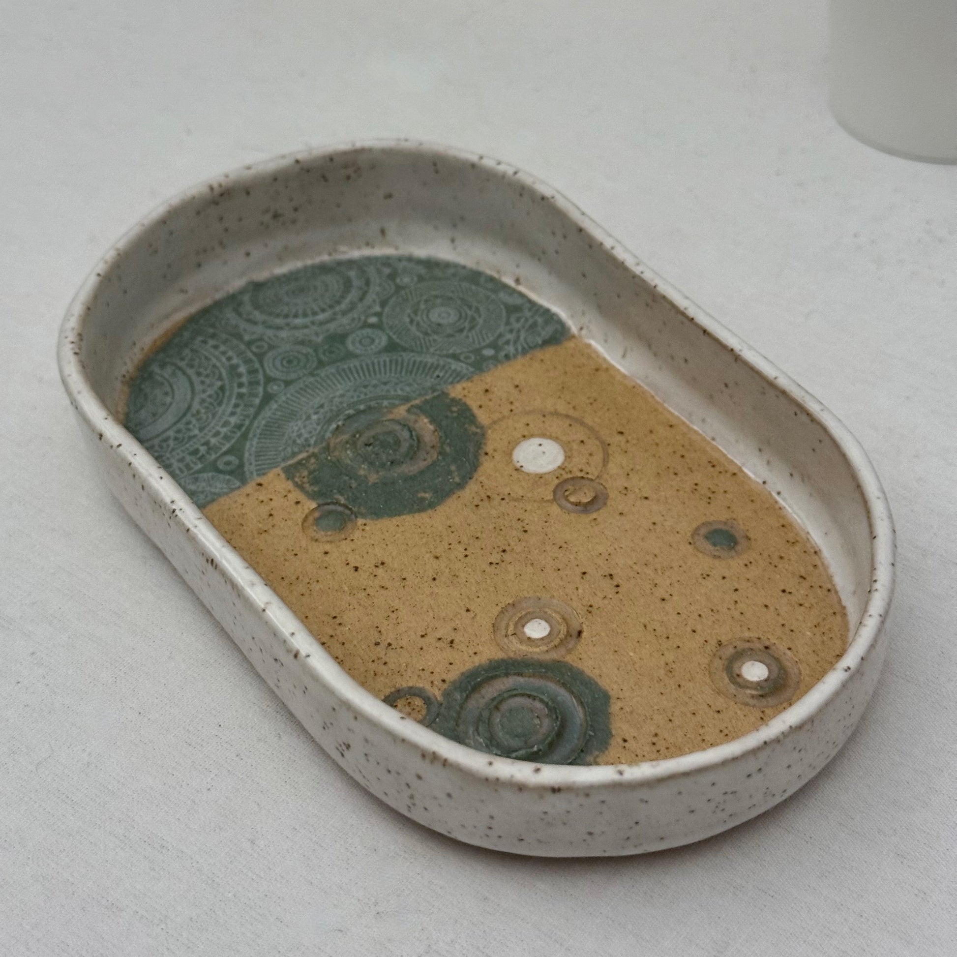 Ceramic dish with abstract patterns on a light gray background